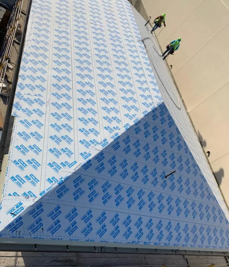 Professional roofers installing underlayment on a metal roof in Opp